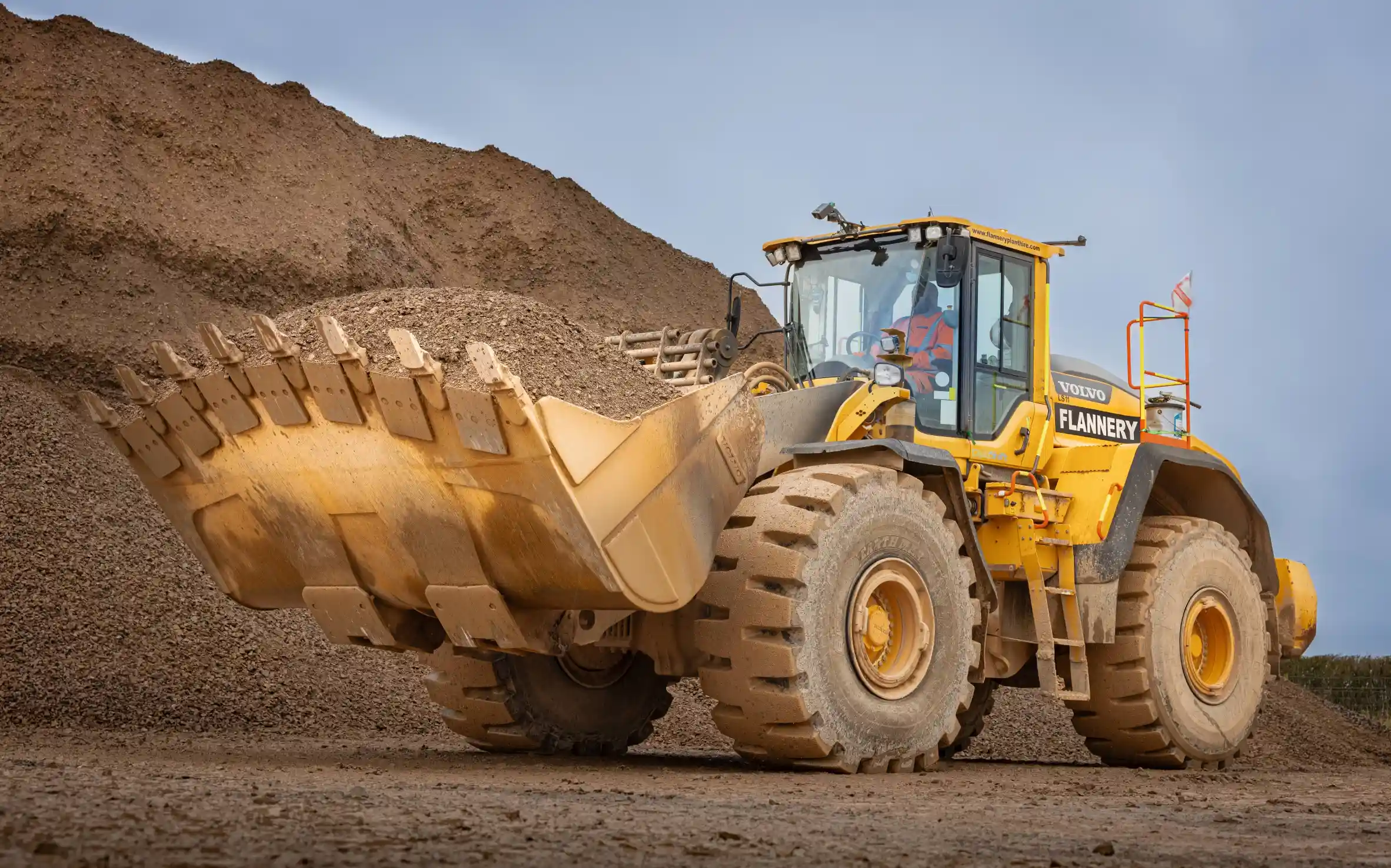 Front loading shovel holding stone on a quarry site.